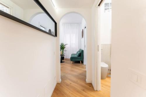 een hal met witte muren en een groene stoel bij Frascati's Most Exclusive Stay Central Square in Frascati