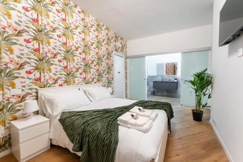 ein Schlafzimmer mit einem großen Bett mit geblümter Tapete in der Unterkunft Frascati's Most Exclusive Stay Central Square in Frascati