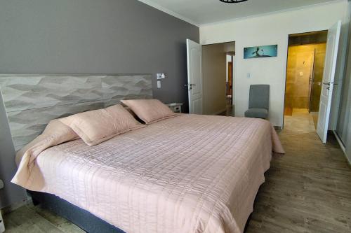 a bedroom with a large bed with a pink comforter at Arrabal.Tupungato in Tupungato