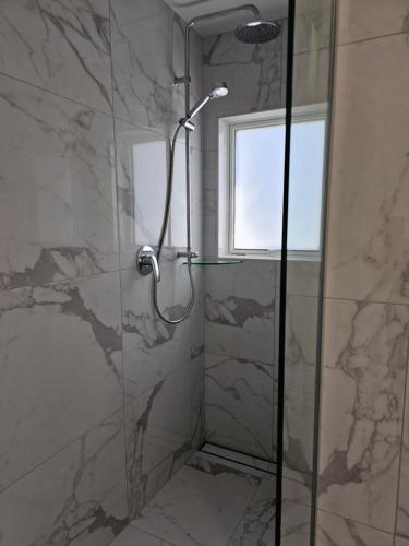 a shower with a glass door in a bathroom at Pyramid beach unit in Karikari Peninsula