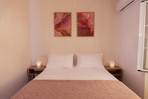 シダリにあるMisemeliのベッドと壁に2枚の絵が飾られた寝室