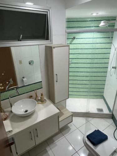 une salle de bain avec lavabo et douche dans l'établissement Melhor Apto no Centro ao lado da Praia e Comércio, à Guarapari