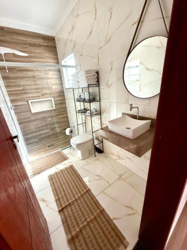 a bathroom with a sink and a toilet and a mirror at A Casinha in Socorro