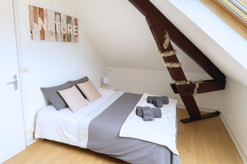 a bedroom with a bed with white sheets and pillows at Gîte cosy et paisible près de La Mongie in Campan