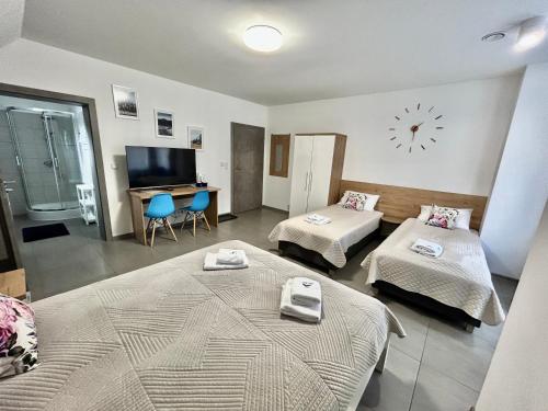 een kamer met twee bedden en een klok aan de muur bij WILLA DobraNocka in Szklarska Poręba