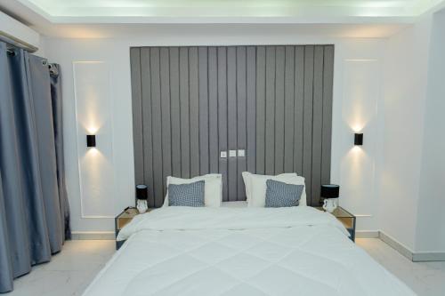 a bedroom with a large white bed with blue pillows at Adèle résidence in Mandanou