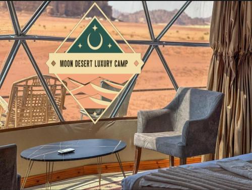 a room with a table and a chair and a window at Moon Desert Luxury Camp in Wadi Rum