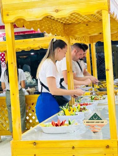 a group of people preparing food at a table at Moon Desert Luxury Camp in Wadi Rum