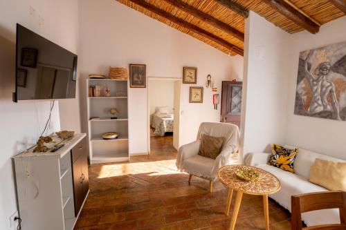 a living room with a couch and a table at Cantinho Alentejano-Rua das Hortas, Corte Pao e Agua in Mértola