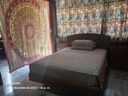 a bed in a room with rugs on the walls at Chema in Mocoa