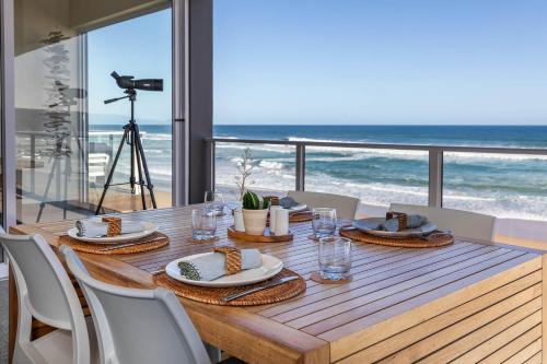 einen Holztisch mit Meerblick in der Unterkunft Dune Beach House in Wilderness