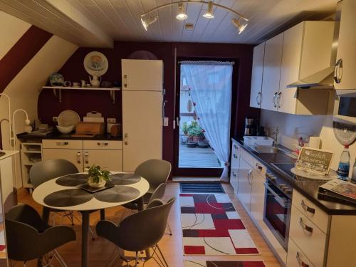een keuken met een tafel en stoelen in een keuken bij Ferienwohnung Leo in Eschwege