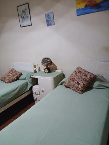 a bedroom with two beds and a lamp on a night stand at Las Gemelas in Rosario