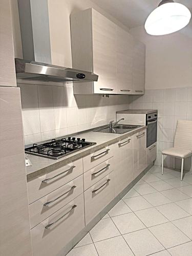 a white kitchen with a stove and a sink at Villa dei Filari in Tramonti
