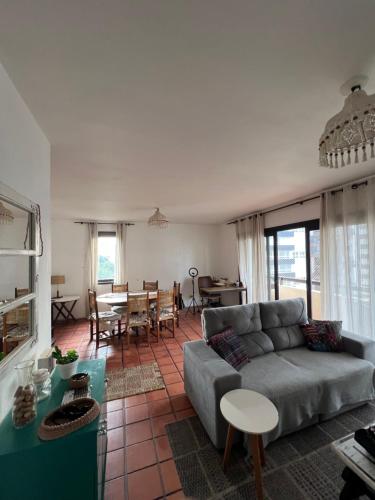 un soggiorno con un divano e un tavolo di Apartamento com suíte Praia Grande Torres a Torres