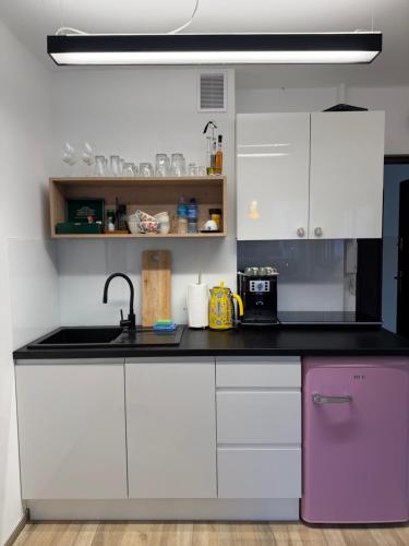 eine Küche mit weißen Schränken und einem lila Kühlschrank in der Unterkunft Apartament Centrum Warszawy Pereca in Warschau