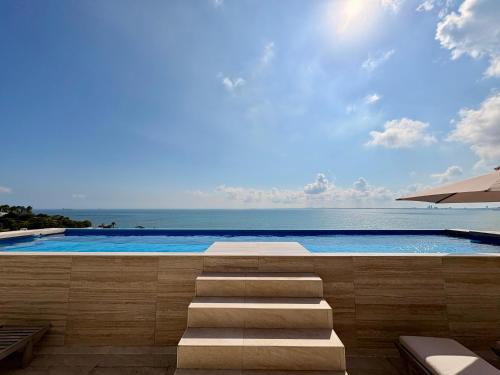 a swimming pool with a view of the ocean at Luxury 2-Bedroom Apartment with amazing view - Infinity Pool and Rooftop in Building in Veracruz