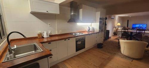 a kitchen with white cabinets and a sink and a table at Moramay in Punta del Este