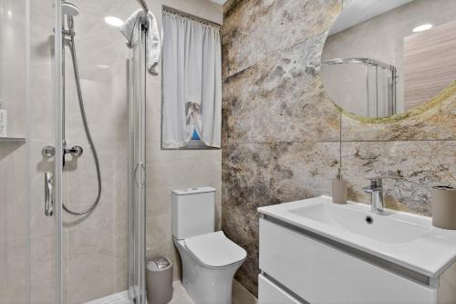 a bathroom with a toilet and a sink and a shower at Contemporary Retreat in St. Paul's Bay