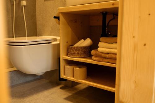 a bathroom with a toilet and some towels at YASNA Apartments in Demanovska Dolina