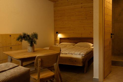 a bedroom with a table and a bed and a table and chairs at YASNA Apartments in Demanovska Dolina