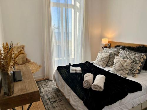 ein Schlafzimmer mit einem Bett mit Kissen und einem Fenster in der Unterkunft Villa Ô Dunes in Châtelaillon-Plage