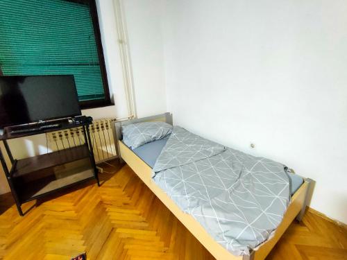 una camera da letto con un letto e una TV a schermo piatto di Apartman Branko Radicević a Negotin