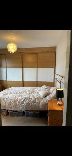 a bedroom with a bed and a table with a lamp at En-Suite Private Room Brocton Village in Bednall