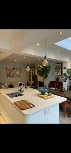 a kitchen with a counter top and a living room at En-Suite Private Room Brocton Village