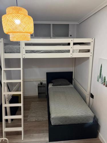 a bedroom with two bunk beds and a lamp at Casa de ogracia in Rojales