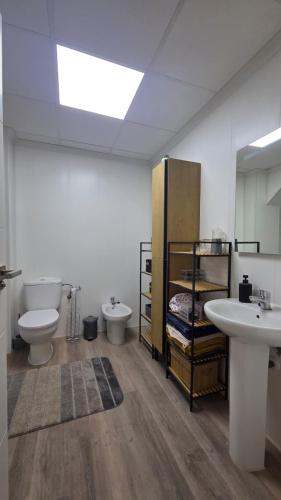 a bathroom with two sinks and a toilet and a mirror at Casa de ogracia in Rojales
