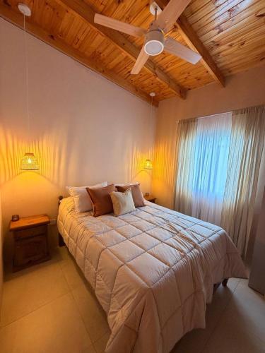 a bedroom with a large bed with a ceiling fan at QUINTA BELEN Cañuelas in La Porteña
