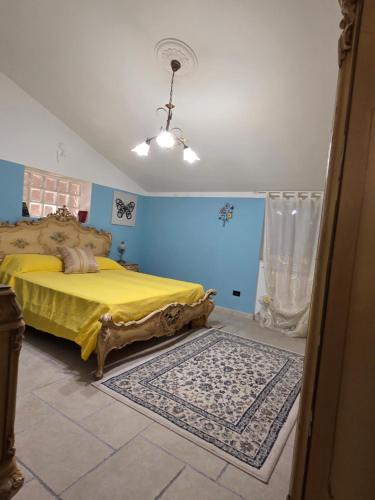 a bedroom with a yellow bed and a blue wall at Farfalle in fiore Guesthouse in Roccasecca