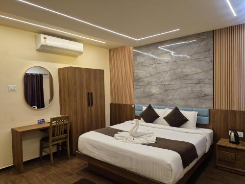 une chambre avec un lit, un bureau et un miroir dans l'établissement Holiday Heaven Munnar, à Chinnakanal