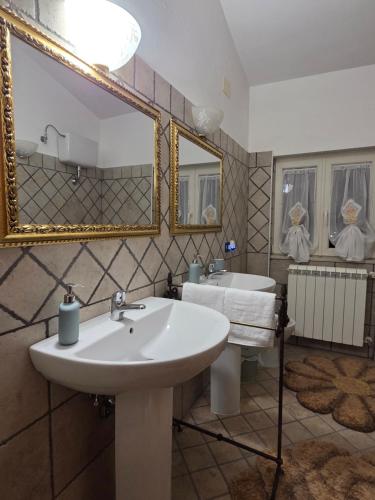 a bathroom with two sinks and a large mirror at Farfalle in fiore Guesthouse in Roccasecca