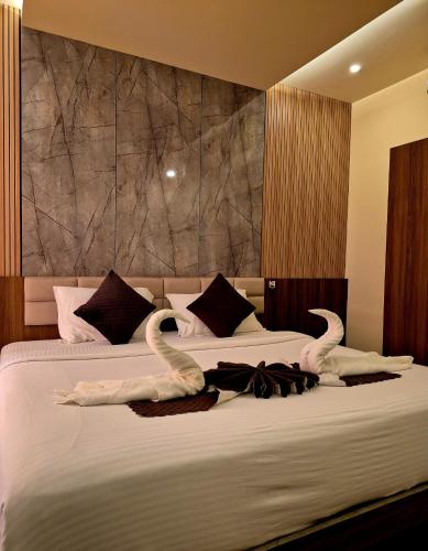 a bedroom with two swan towels on a bed at Holiday Heaven Munnar in Chinnakanal