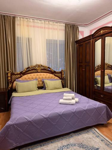 een slaapkamer met een paars bed met handdoeken erop bij Сункар in Uchitelʼ