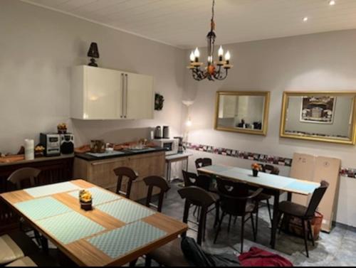 eine Küche und ein Esszimmer mit Tischen und Stühlen in der Unterkunft Hotel Bender in Eschweiler