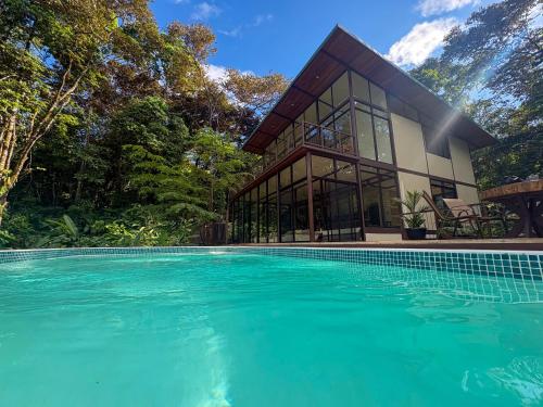 a house with a swimming pool in front of it at Maze Lodge in Puerto Jiménez