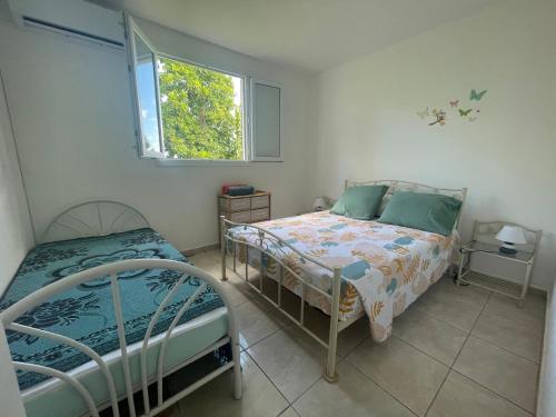 a bedroom with two beds and a window at Rayon des îles bien désirée in Saint-François