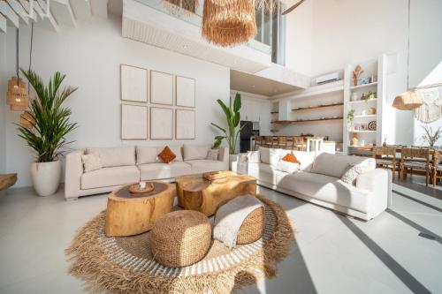 a living room with white furniture and a table at Sayan Villas in Hikkaduwa