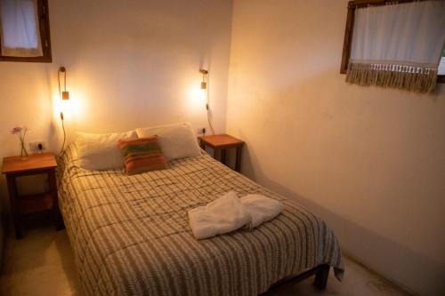 a bedroom with a bed with two towels on it at La Cabañita de Tilcara in Tilcara