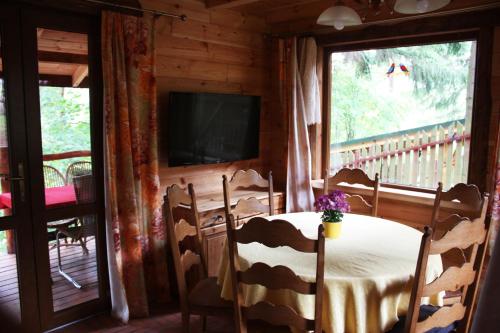 a dining room with a table and a television in a cabin at Domek Moczykija in Szypliszki