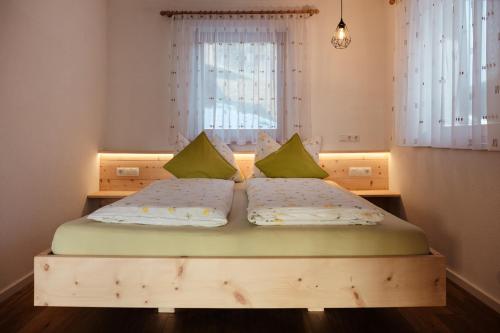 una camera con 2 letti con cuscini verdi di Prestihof a San Vigilio Di Marebbe