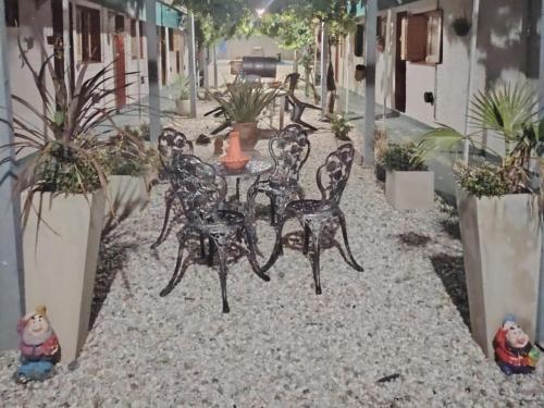a patio with a table and chairs and potted plants at Terranova in Capilla del Monte