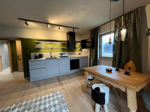 - une cuisine avec une table en bois et une table sidx sidx sidx dans l'établissement GOLDMARIE - Apartments, à Aschau