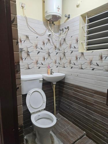 a bathroom with a toilet and a sink at Rove Haven Condo in Bangalore