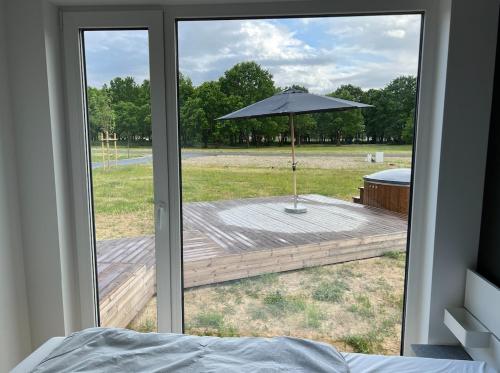 an open door to a deck with an umbrella at Airpark-Lodge in Lärz