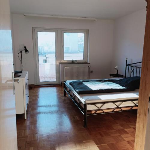 una camera da letto con un letto e due finestre di City-Quartier a Bad Mergentheim