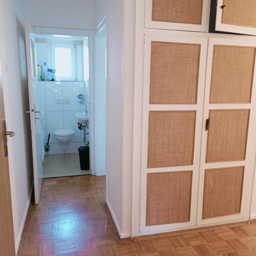 a bathroom with a toilet and a bathroom with a door at City-Quartier in Bad Mergentheim